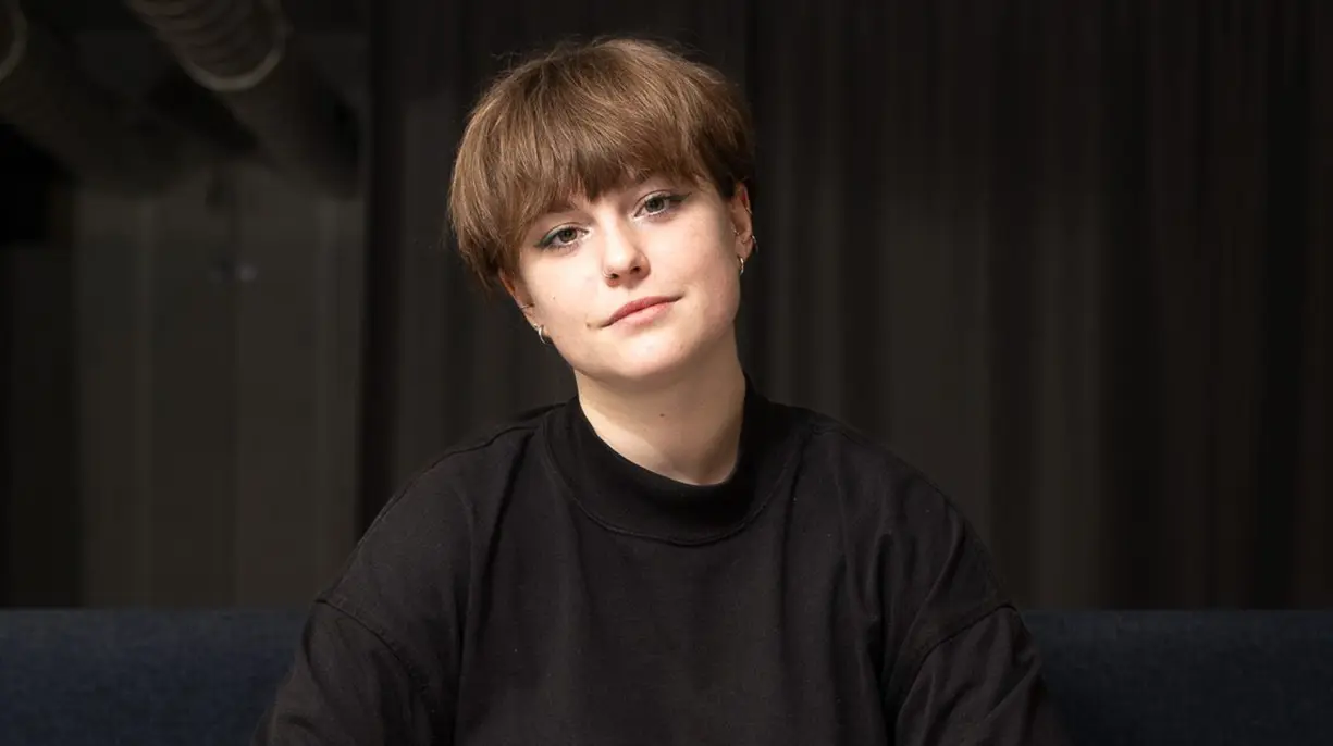 Cara Mia Schneider, Team und One-on-One Coach bei Traffo, sitzt entspannt auf einem Sofa.
