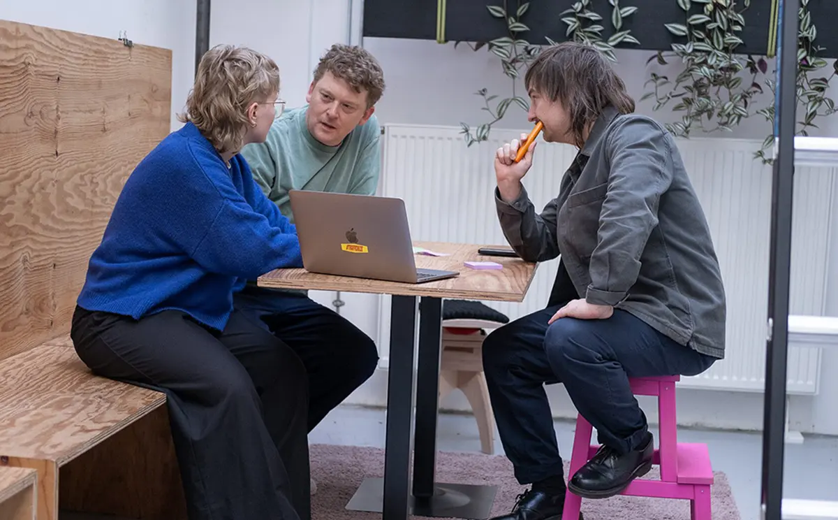 Team Workshop bei Traffo in Stuttgart, drei Personen im Austausch am Tisch
